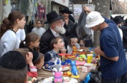     Hagyományos ortodox zsidó öltözetben férfiak, nők, gyerekek lepik el az egyébként csendes utcákat.
Mindenki szeretne valami szépet vásárolni szeretteinek. Hanuka az ajándékozás ünnepe.            