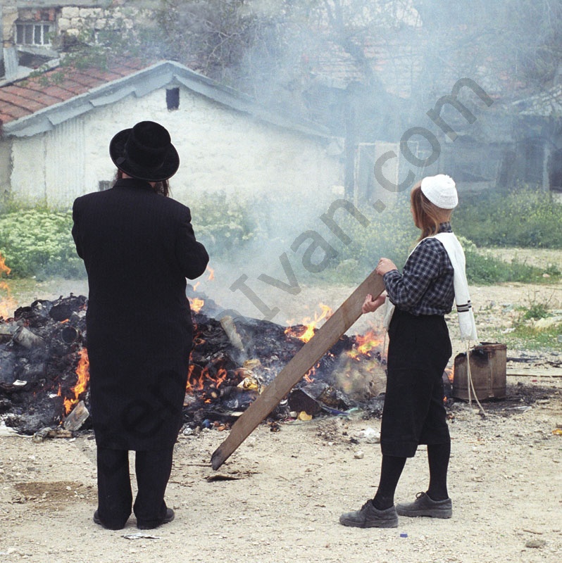         Az ultraortodox hagyományoknak megfelelő ruhában apa és fia égetik a homecet Mea Shearimban a házuk elött. Közösen emlékeznek a zsidó nép csodálatos megmeneküléséről Egyiptomból. Ez a peszachi